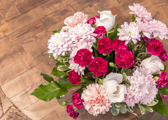 Closeup pink flora in a bunch of colorful mixed flowers and green leaves on white background, depth of field. Beautiful fresh floral decorating for a romantic anniversary celebration with copy space.