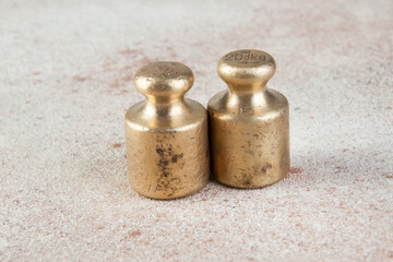 Antique bronze weights for scales on concrete background.