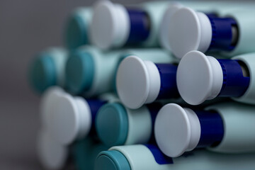 Bokeh and closeup of backends and fronts of syringe self application pens on rustic gray kitchen counter background. Studio medical equipment still life concept with auto-injector disposable devices. © Maarten Zeehandelaar