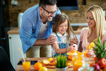 Happy family in the kitchen making orange juice