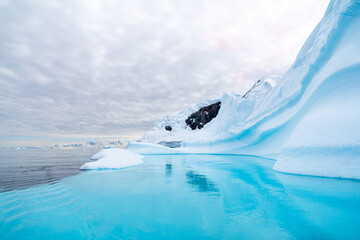 an iceberg in Antarctica turns the water surrounding it a wonderful turquoise color
