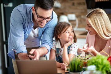 Family using laptop in kitchen