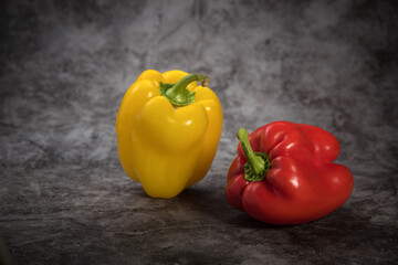 Sweet Bulgarian pepper of yellow and red color on a mottled background