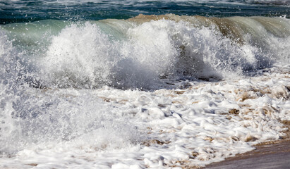 Breaking wave on sandy beach