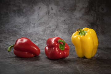Sweet Bulgarian pepper of yellow and red color on a mottled background
