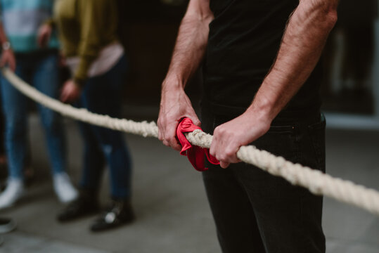 Brazos fuertes que sostienen un lazo rojo en el país vasco jugando a un juego tradicional llamado soca tira..