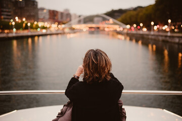 Señora mirándooslas el horizonte viajando en un barco en el rio de bilbao con fondo desenfocadlo...