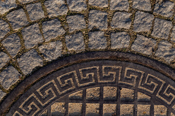 part of a road hatch with Greek ornament on a stone road
