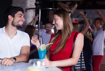 happy man and woman on party in the club with cocktails