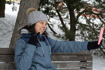 latin women using her phone in botanical garden montreal in the middle of the canadian winter