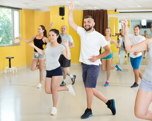 Fototapeta na wymiar Dancing couples learning swing at dance class