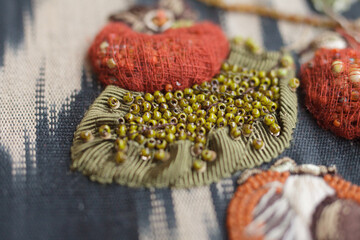 Couture embroidery of persimmon on ikat fabric. Still life with fruits