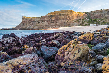 Fototapeta na wymiar Perspective of wet rocks next to the Atlantic Ocean at Calada beach, Ericeira - Mafra PORTUGAL