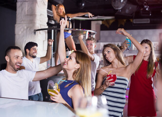 Fototapeta premium Female and male with cocktails dancing in the night club on party