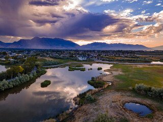 Obraz premium Dramatic clouds over a mountain landscape are reflected on the lake - aerial