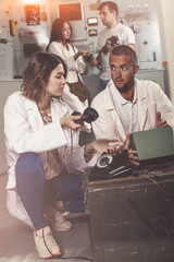 Obraz premium Focused girl and guy checking telephone set while trying to get out of escape room stylized as underground shelter