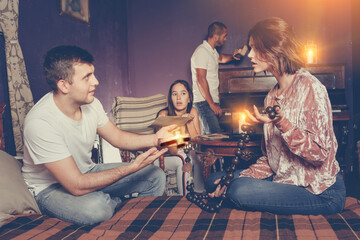 Young friends looking at wooden rosary while solving conundrum as detectives in quest room with old...