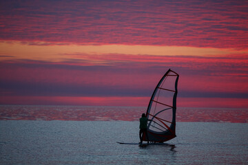 Windsurfer at sunset background. Sunset and windsurfing.