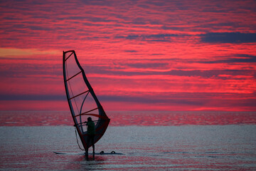 Windsurfer at sunset background. Sunset and windsurfing.