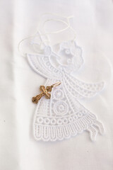 Christening accessories: little golden cross on embroidery of angel 