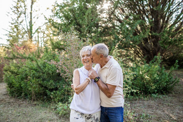 Senior couple in love and very happy enjoying a walk in the field at sunset