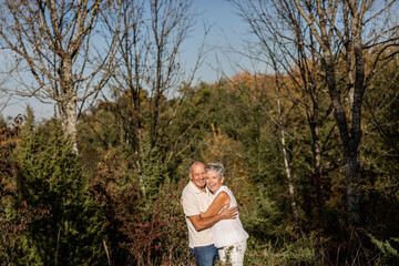 Senior couple in love and very happy enjoying a walk in the field at sunset