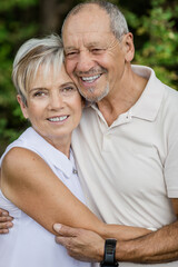 Obraz premium Senior couple in love and very happy enjoying a walk in the field at sunset