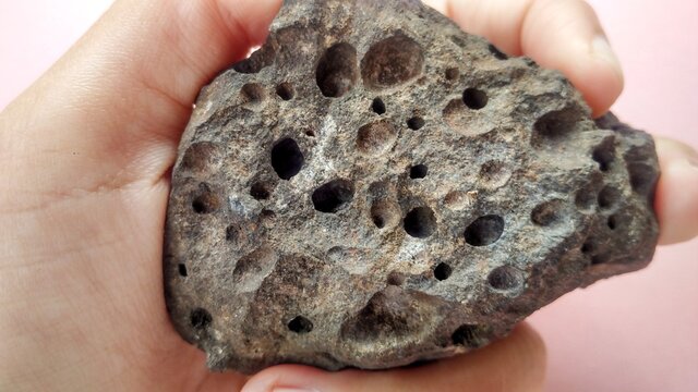 Extrusive volcanic igneous rock, vesicular basalt. Dark brown and heavier. Java trench on active subduction zone, Indonesia