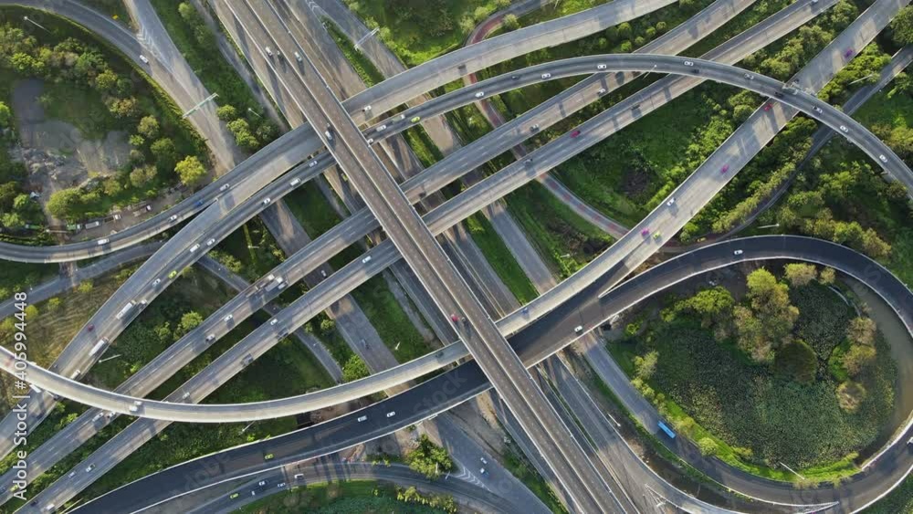 Wall mural 4K. Aerial view of road interchange or highway intersection with busy urban traffic speeding on the road. Junction network of transportation taken by drone. - Wall murals