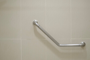 Close up handrail on the tile wall for support disabled and elder people. Safety concept.