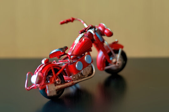 Miniature Old Red Motorcycle Model On A Tablecaptured From Behind