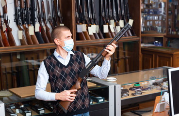 Naklejka premium Seller demonstrates a combat winchester in the gun store