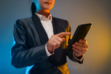 Business woman holding smart phone in black suit.