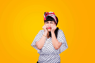 Wow, Closeup red head young woman pretty amazed pinup girl in button shirt excited surprised shocked looking up to side retro vintage 50s hairstyle on yellow wall. Cute face expression