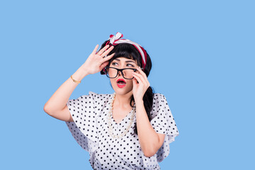 Vision. Closeup attractive fashion cute pinup girl wearing eyeglasses woman holding pair of glasses taking them off she does not need anymore surgical correction of eyesight concept blue background