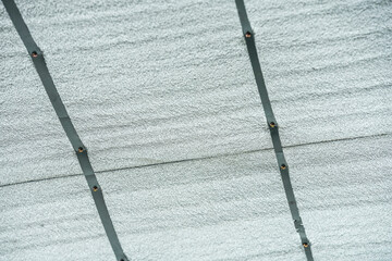 View of exposed aluminum foil for ceiling thermal insulation held in place with metal strips and...
