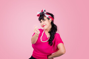 Attractive energetic Asian woman happy isolated on pink studio background.Retro vintage 50's style Emotion face expressi