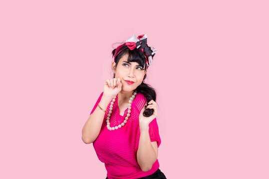 Attractive energetic Asian woman happy isolated on pink studio background.Retro vintage 50's style Emotion face expressi