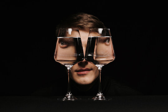 Fototapeta portrait of a strange man looking through two glasses of water