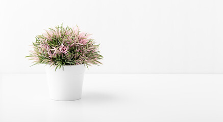 Artificial plant in pot on white table background