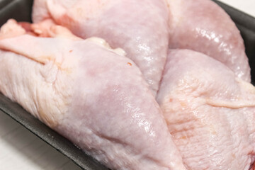 Close-up of raw chilled chicken legs on a substrate.