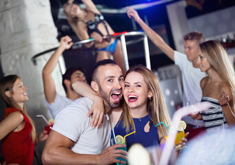 Fototapeta premium Happy man and woman dancing and hugging on party in the club