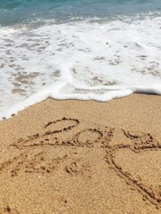 inscription on the sand 2019, waves.