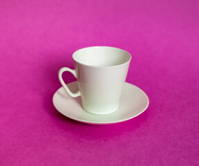 White purchased porcelain coffee Cup with saucer closeup on pink background