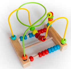 Colored purchased children's toy made of painted wood and metal close up on a white background