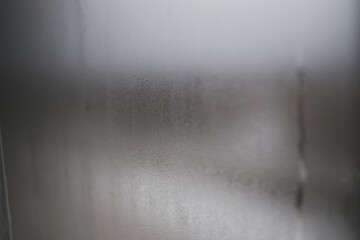 The window was fogged up. Drawing on the wet glass of a window on a gloomy day, isolated at home. Gray color