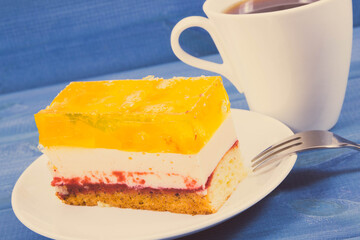 Creamy fruit cake with jelly and cup of coffee for different occasions. Festive dessert