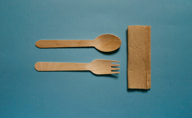 flat lay wooden spoon and fork isolated on blue background