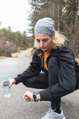 Adult caucasian woman in 40s exercising / jogging on a suburb road in winter / autumn season time.