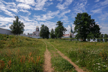 Fototapeta na wymiar View of the Valday Iversky Monastery and a country road on a sunny summer morning. Valdaysky District of Novgorod Oblast, Russia. August 2020.
